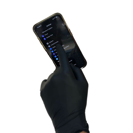 a hand in a black glove holding a cell phone