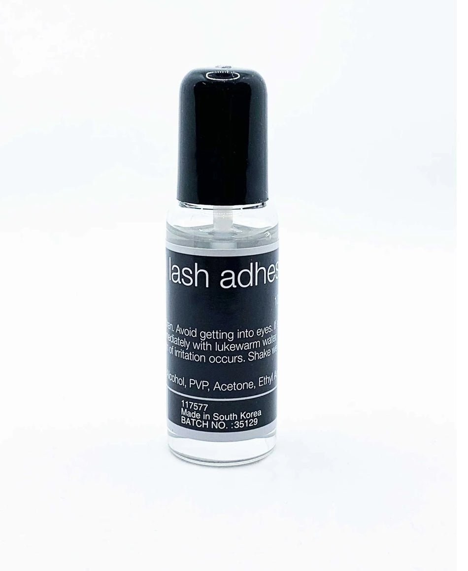a bottle of lash remover adhesive on a white background